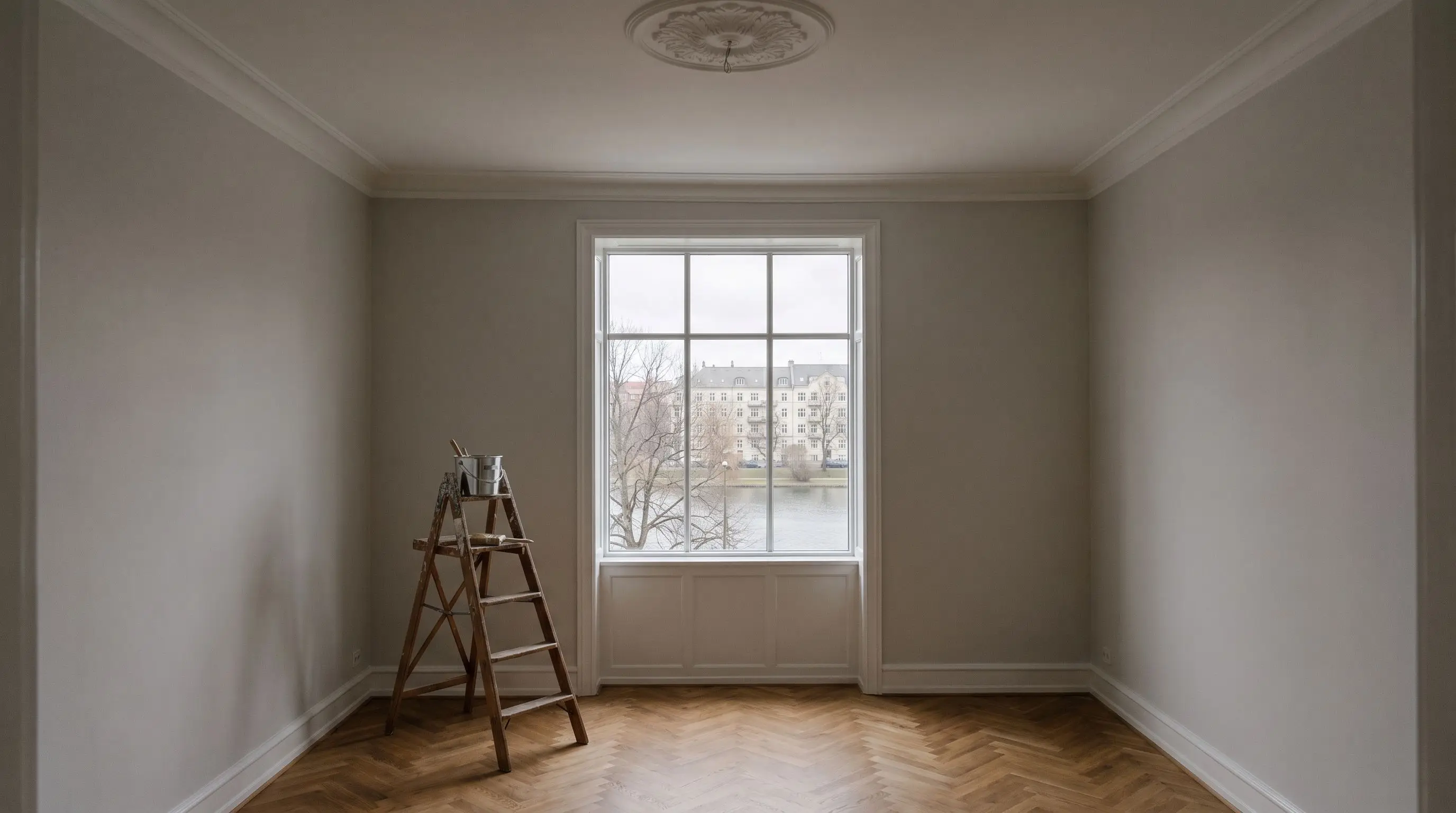 Nymalet, tom stue i en ældre ejendom på Østerbro med loftsrosette, sprossede vinduer ud mod Søerne og sildebensparket